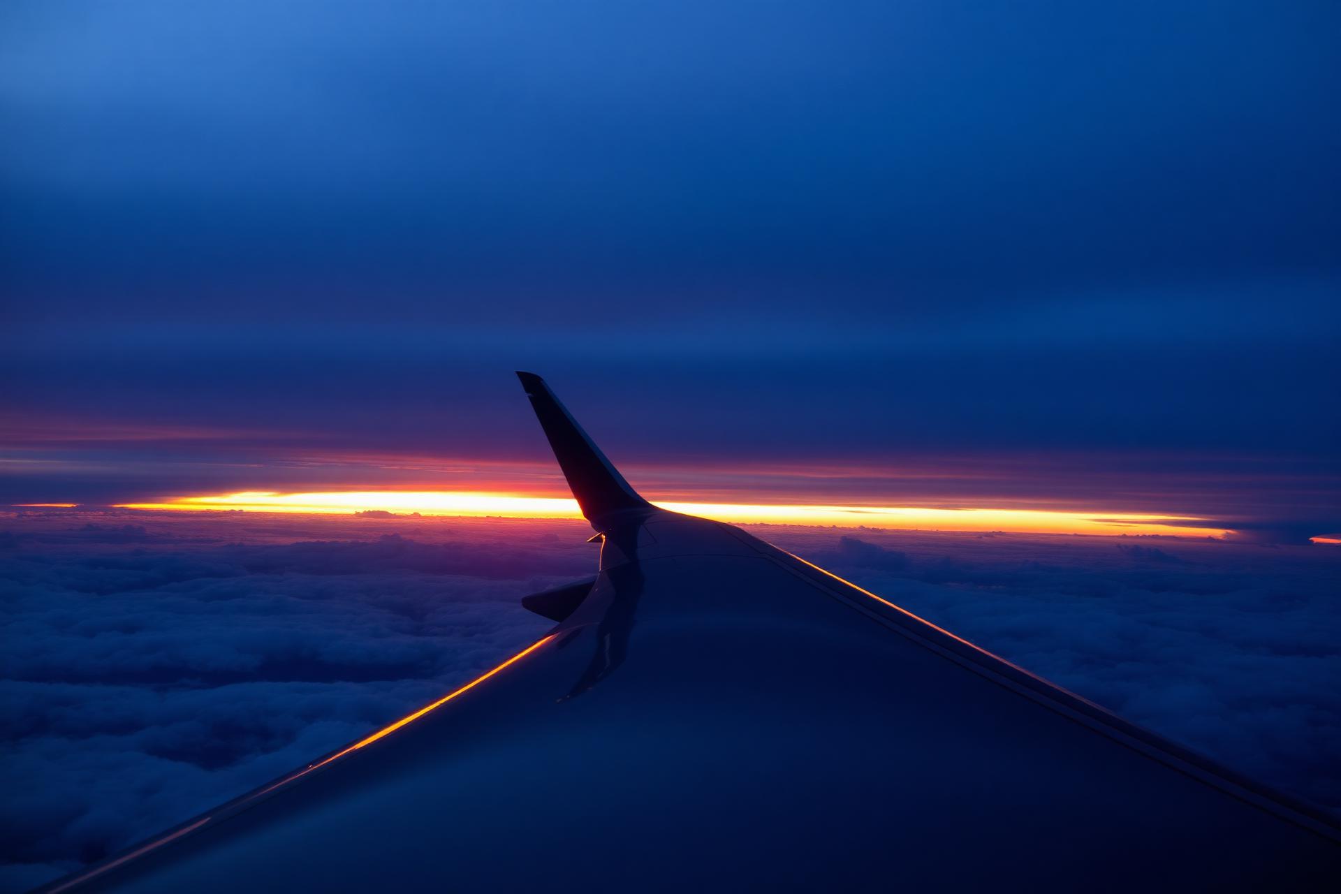 Airplane wing over dramatic sunset clouds